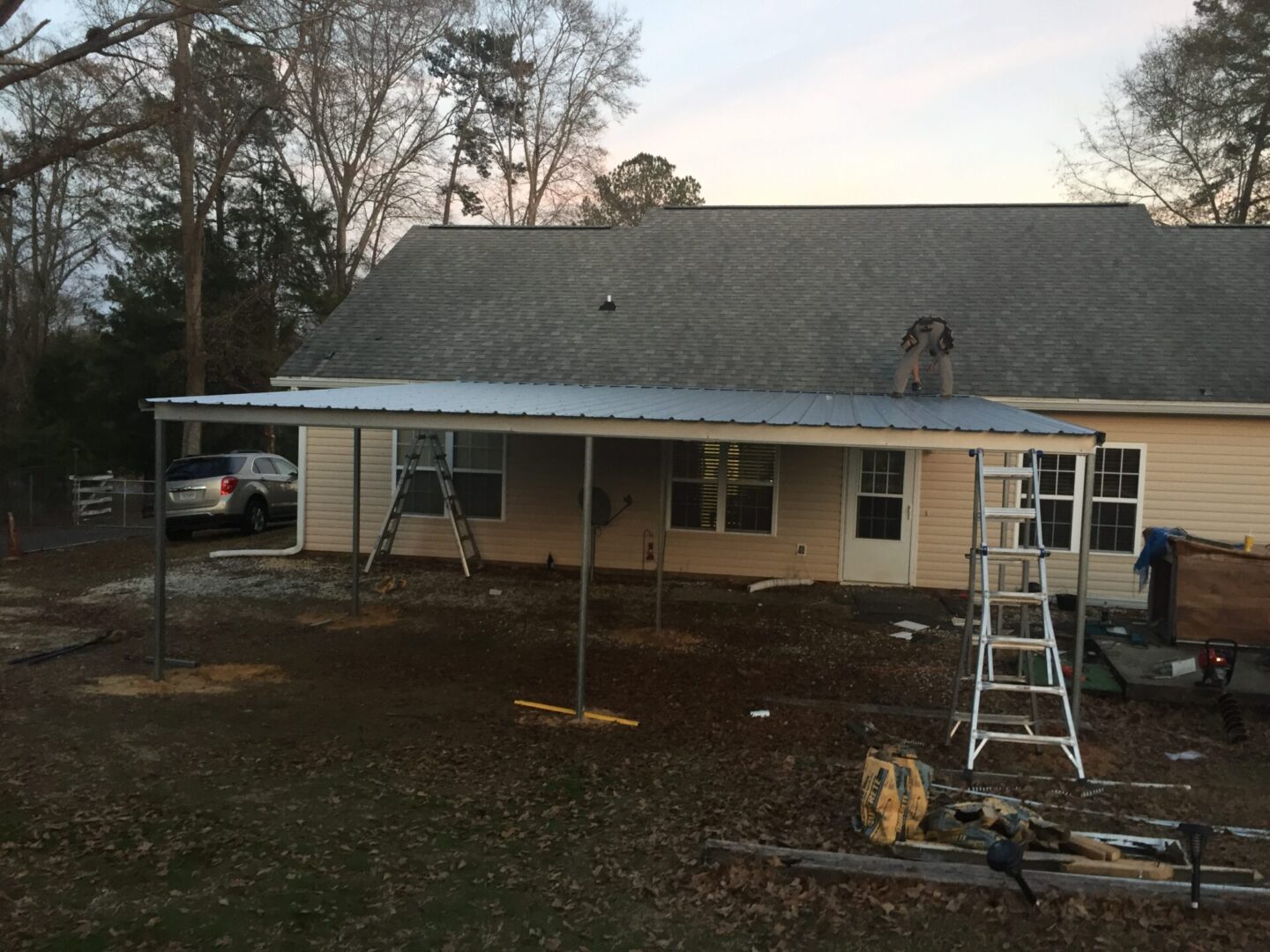 House with scaffolding and ladders during roof renovation.